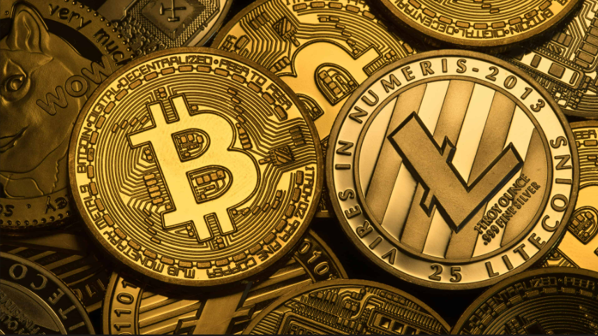 Close-up of physical Bitcoin, Litecoin, and Dogecoin commemorative coins piled together